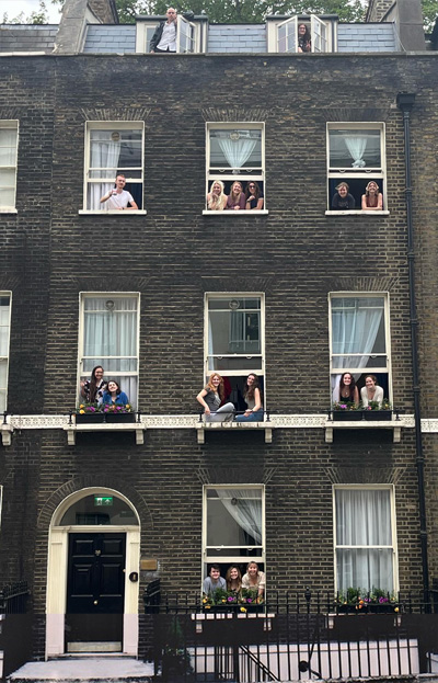 Old photo of students sitting in windows of old building