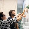 Professor and two students point to large dry erase board