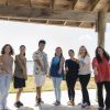 Professor and eight students stand side by side showing off their bracelets