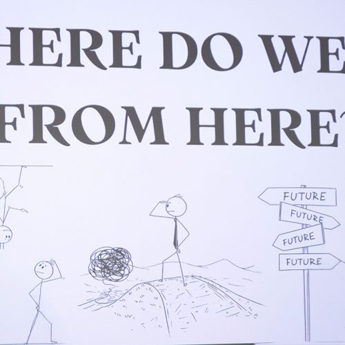 Display screen that reads Where Do We Go From Here? with stick figure drawings below the text